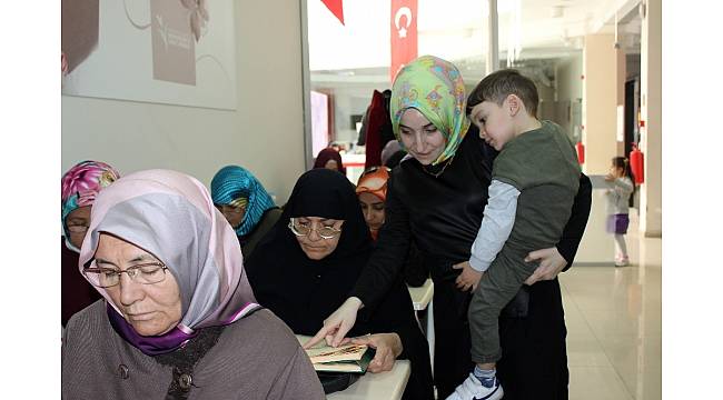 Kucağında çocuğu elinde kalemi öğrencilere ders veriyor